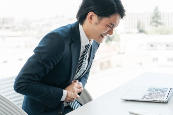 お腹をおさえる男性の写真